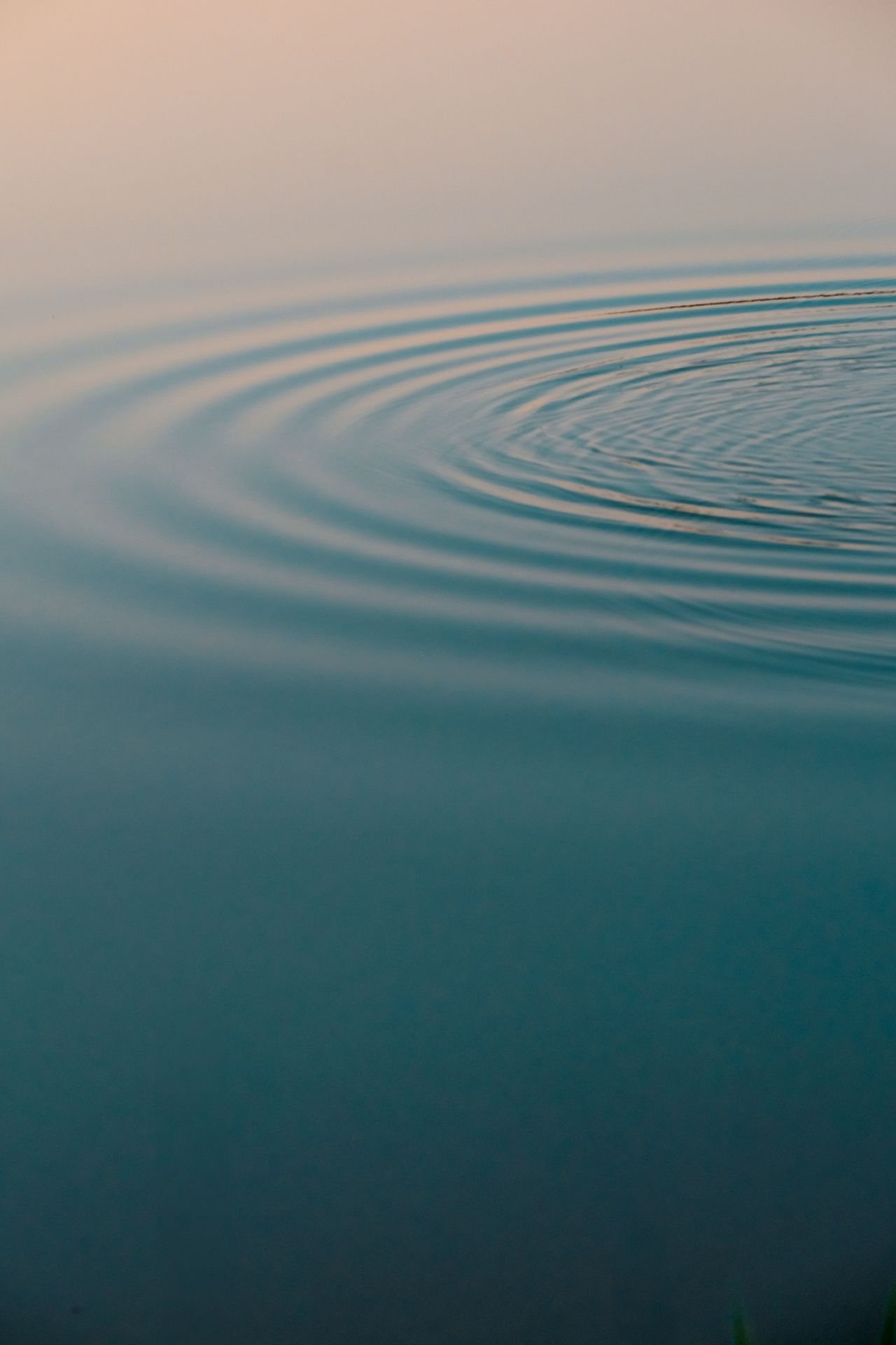 Gentle ripples on calm teal water