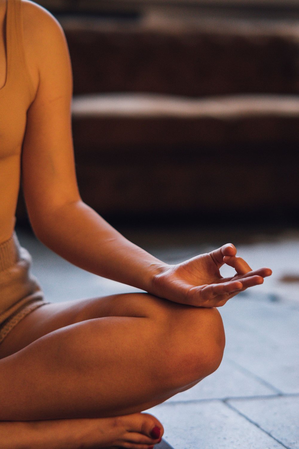 A hand resting in a meditation mudra on a crossed knee