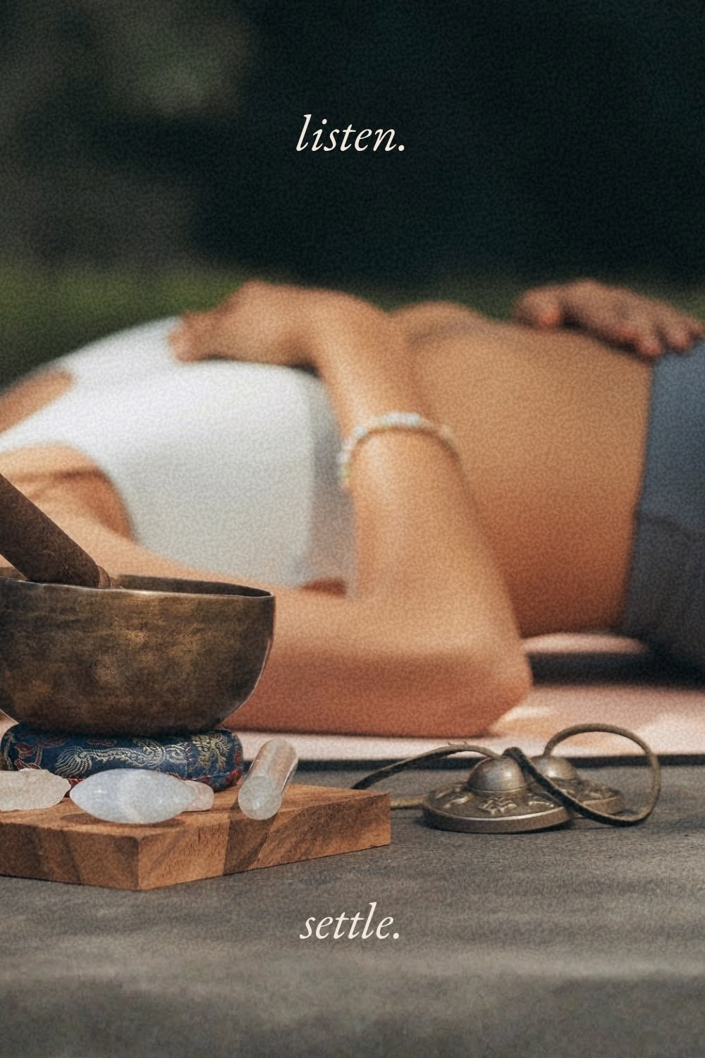 A woman resting beside a singing bowl, with the words listen and settle