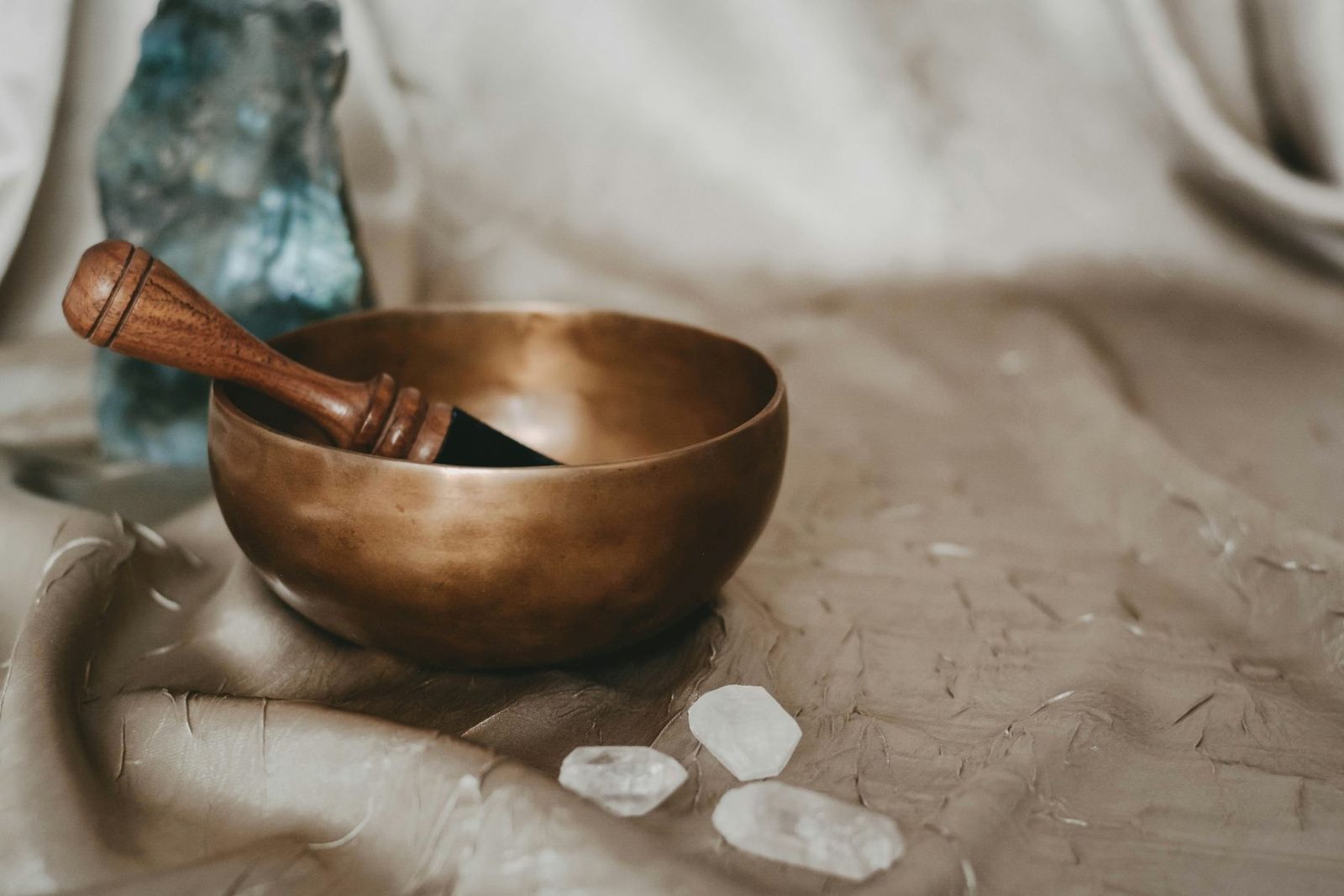Brass singing bowl with crystals on linen