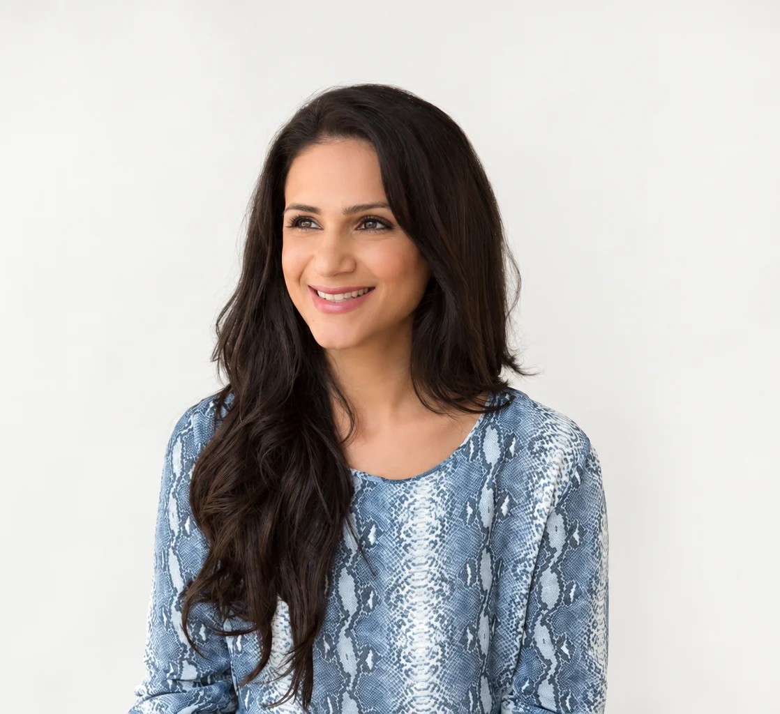 Esha Oberoi sitting on a cream sofa
