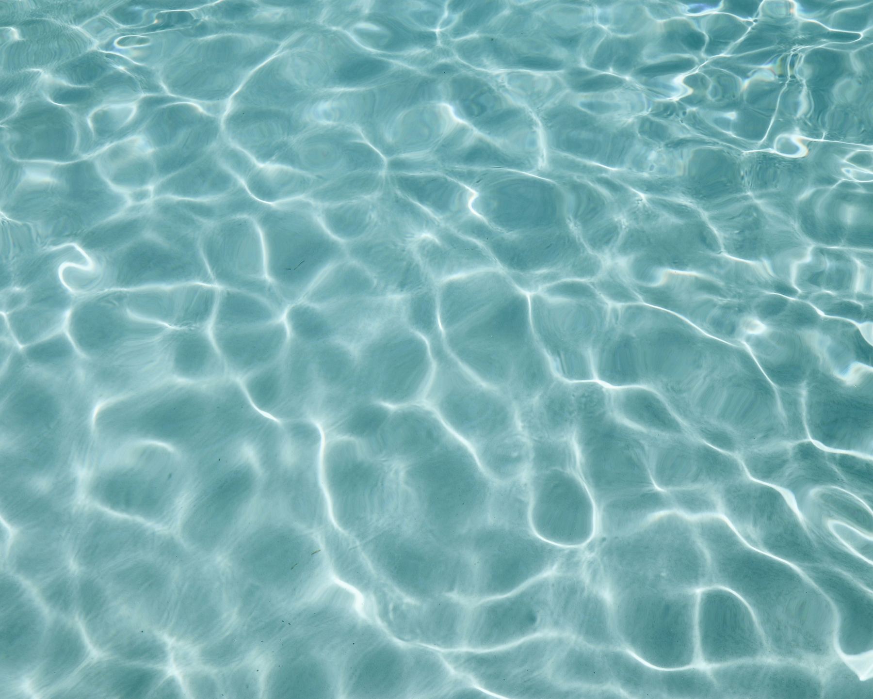 Sunlight moving across clear aqua water